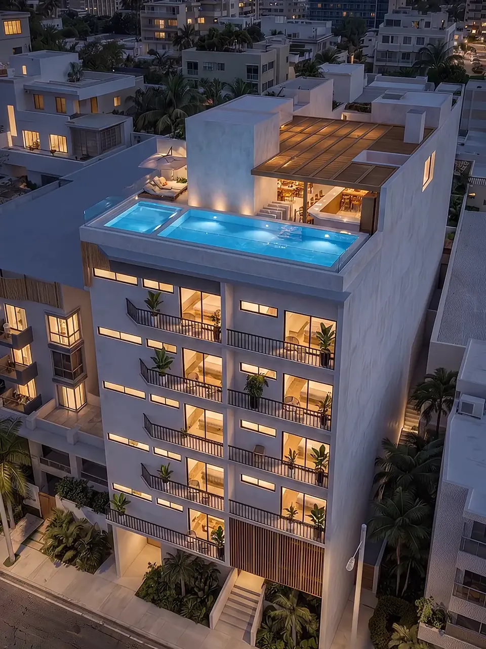 Render nocturno de la torre terminada: la alberca del rooftop encendida y los balcones iluminados