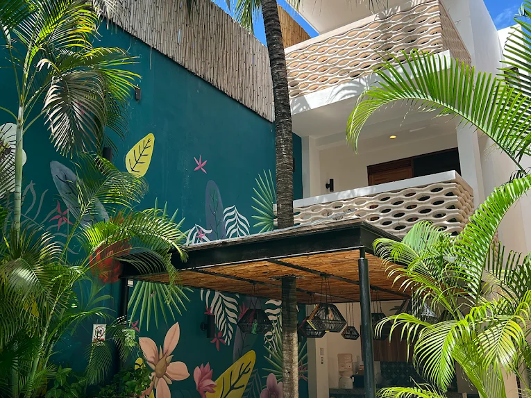 Patio y alberca de Hotel Latino con el mural tropical